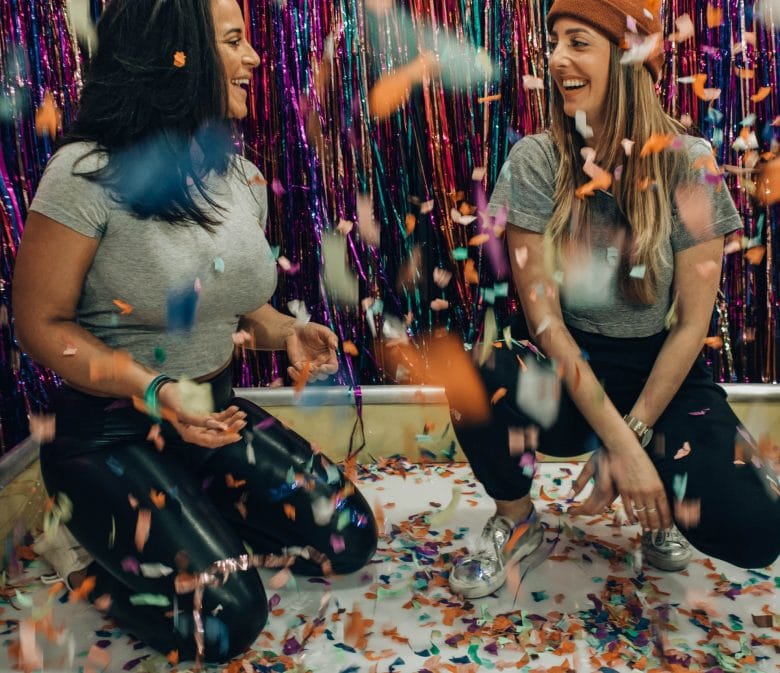 Two girls playing games in confetti