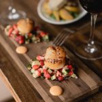 Wooden plate with food and a glass of red wine